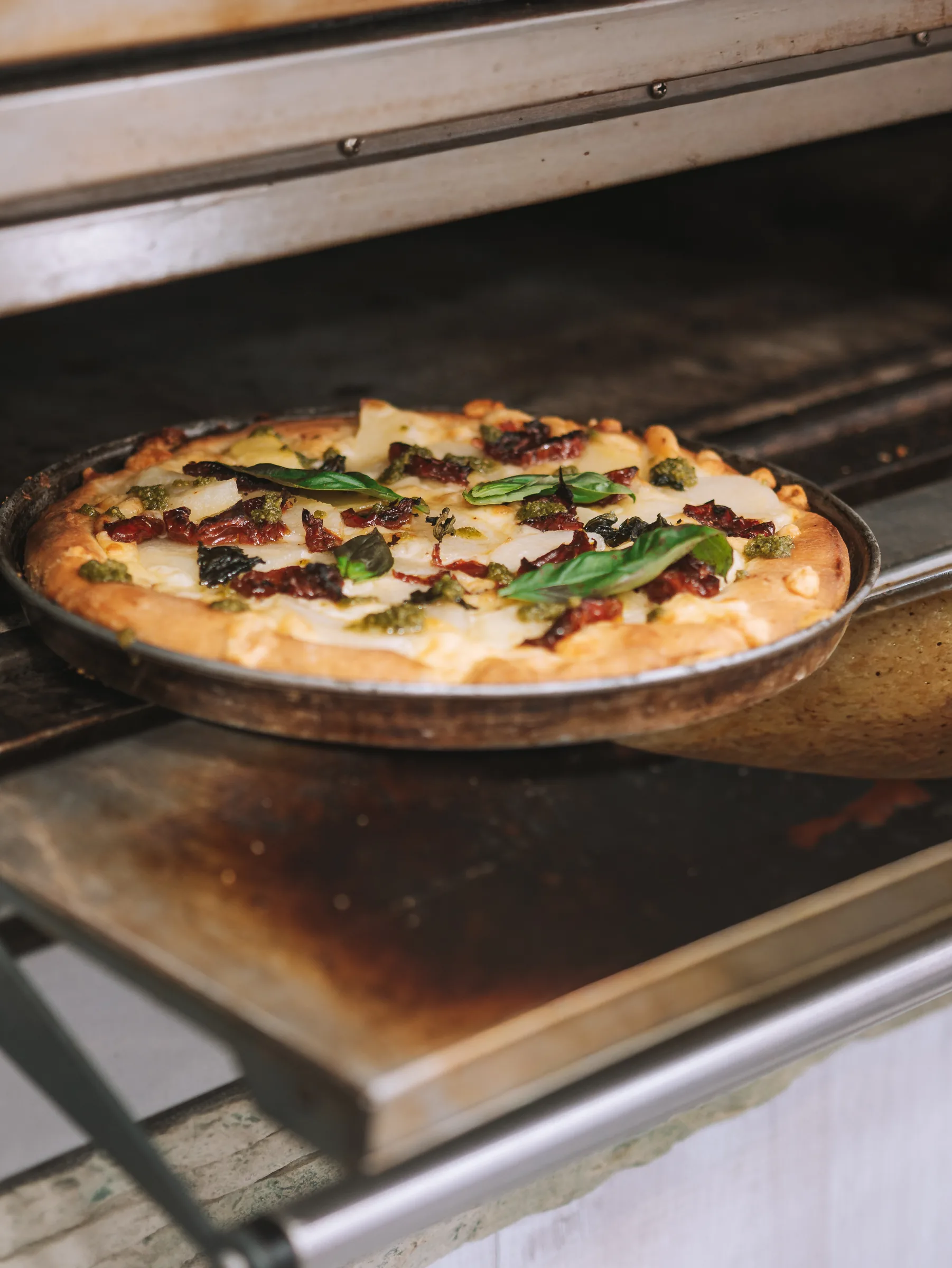 Pizza in teglia in uscita dal forno